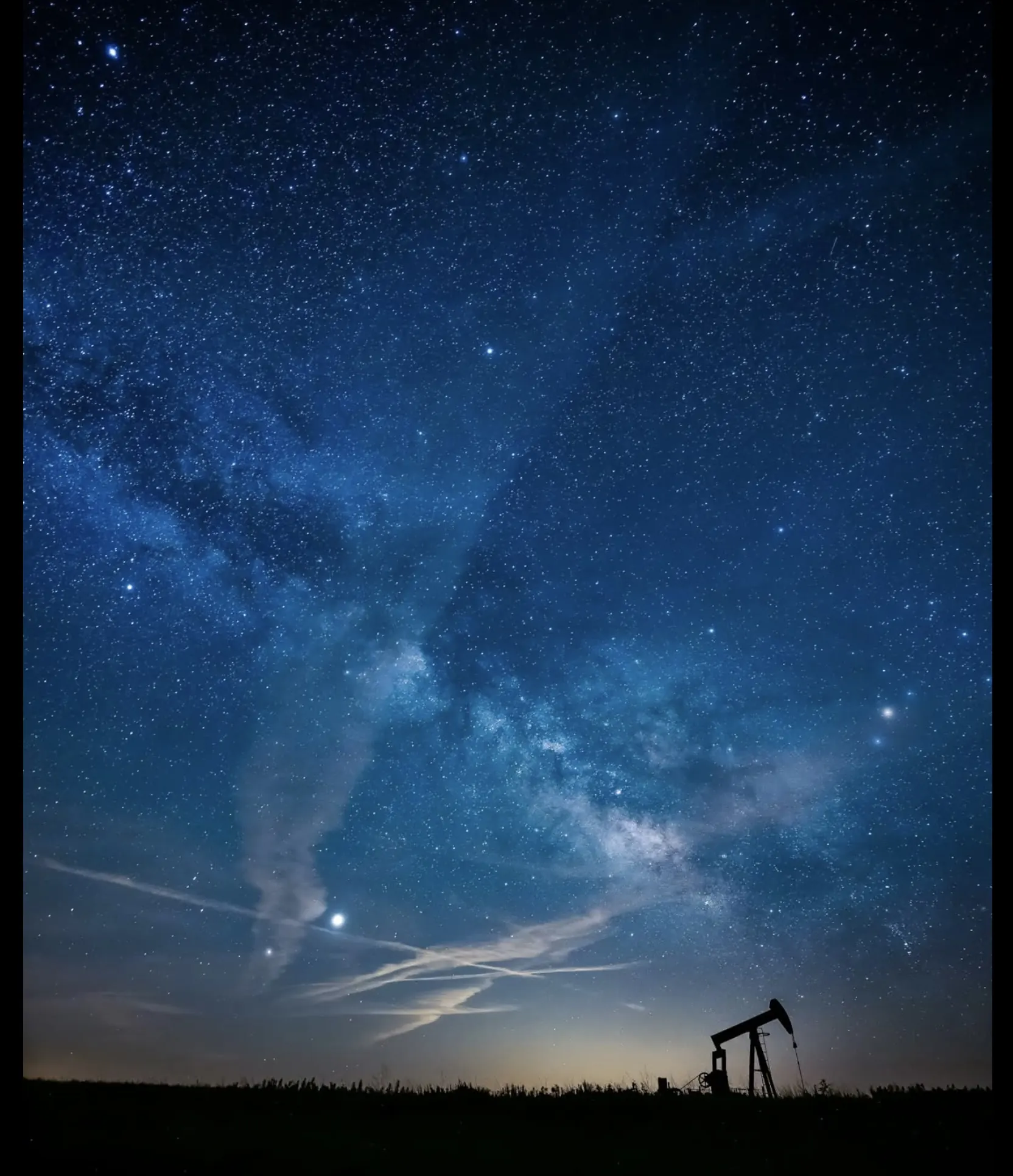 Pumpjack silhouetted against the night sky